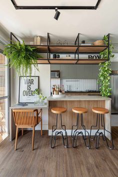 an open kitchen and dining area with wooden stools in front of the counter top