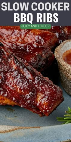 slow cooker bbq ribs on a blue plate with rosemary sprigs next to it