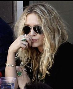 a blonde woman wearing sunglasses sitting at a table