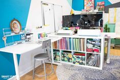 a room with a desk, chair and bookshelf filled with various colored papers