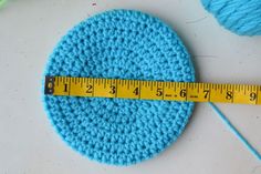 a blue crocheted circle with a measuring tape