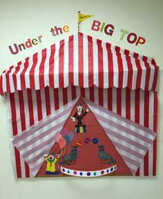 a red and white striped tent with cartoon characters on the top, under the big top