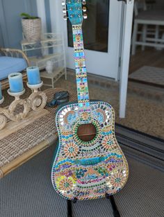 a colorful guitar sitting on top of a wooden stand