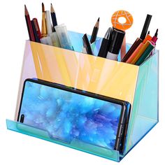 a pen holder with pencils, markers and an iphone in it on a white background