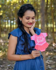 a woman holding a pink paper star with it's a girl written on it