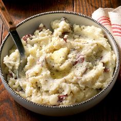 a bowl filled with mashed potatoes on top of a wooden table