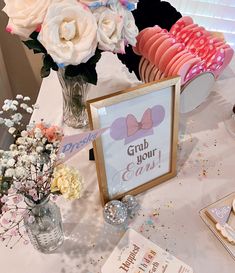 a table that has some flowers and cookies on it with a sign saying grab your ears