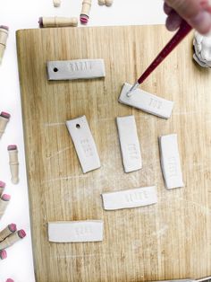 a cutting board with several pieces of paper cut into smaller rectangles on it