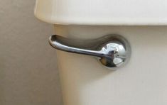 a close up of a toilet with the lid down and handle on it's side