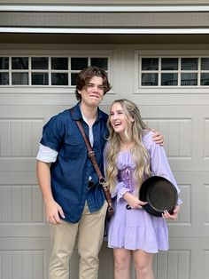 a young man and woman standing in front of a garage door with their arms around each other