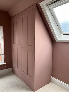 an empty room with pink painted walls and white trim on the window sill is shown