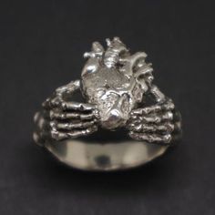 Are you struggle at looking for Unique Claddagh Ring? It is made with a skull hand holding a real human heart. Cool! It's a great gift for memento mori. #MakeItMeaningful #etsyshop #etsyhandmade #etsyjewelry #skull #mementomori Goth Jewelry Men, Symbolic Hand-cast Skull Ring Gift, Hand Cast Skull Ring For Halloween Gift, Weird Rings, Goth Corsets, Heart In Hand, Real Heart, Punk Rings, Goth Ring