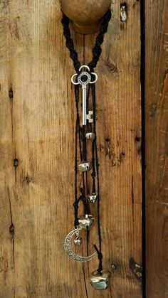 a necklace with an old key hanging from it's side on a wooden wall