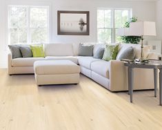 a living room with wood flooring and white furniture