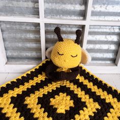 a crocheted bee blanket sitting on top of a window sill