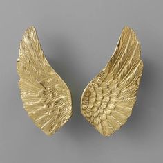 two gold angel wings on a gray background