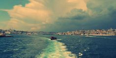 a boat traveling on the water in front of a city