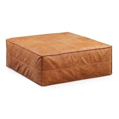 a brown leather square ottoman sitting on top of a white floor