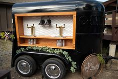 an old fashioned truck has been decorated with plants and bells on the front, along with two wine glasses