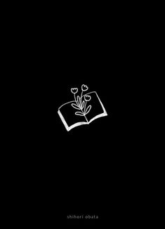 an open book with flowers on it in the dark