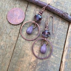 Small purple dangle drop earrings. Lightweight, everyday Czech glass earrings with rustic teardrop dangle and antiqued copper.Small, light-weight copper and Czech glass earrings that are perfect for your summer jewelry collection! The focal piece is a beautiful, faceted purple Czech glass rondelle shaped bead and small glass teardrop dangle in an antiqued copper ring.Product overview:- Made with Czech glass and antiqued copper- Total hanging length is 2", the ring is the diameter of a penny- Sma Purple Drop Earrings, Artsy Earrings, Orange Jewelry, Glass Drop Earrings, Copper Accents, Copper Ring, Purple Earrings, Wrapped Jewelry, Small Light