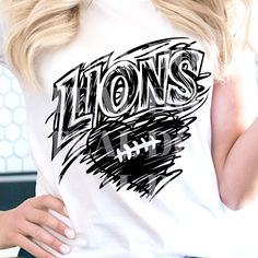 a woman with blonde hair wearing a white lions t - shirt and black jeans, holding a cell phone in her hand