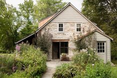 an old stone house surrounded by greenery and trees