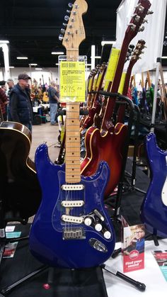 several guitars are on display in a store