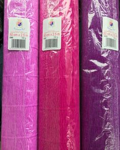 purple and pink plastic bags are stacked on top of each other