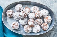 powdered sugar covered donuts in a metal bowl