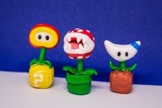 three plastic toy toys with faces and mouths on them sitting in a row next to each other