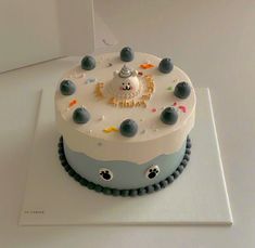 a birthday cake with frosting and decorations on the top is decorated in blue and white