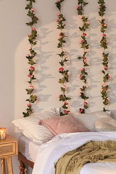 a bed with flowers hanging on the wall above it