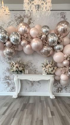 the balloon wall is decorated with pink and silver balloons, flowers and chandeliers