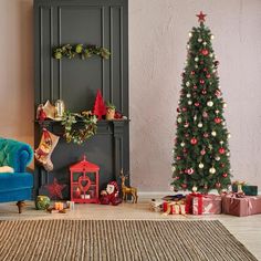 a living room with a christmas tree and presents on the floor next to a blue couch