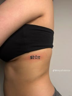 a woman's stomach with the word fit tattooed on her lower back and side