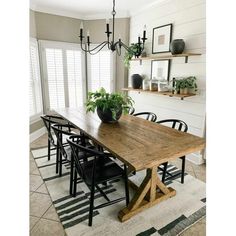 a dining room table with black chairs and a potted plant on top of it