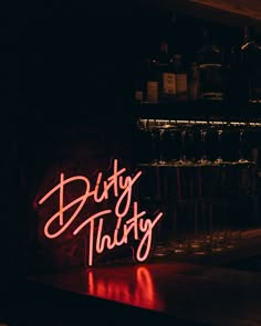 a neon sign sitting on top of a bar