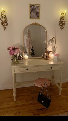 a dressing table with a mirror and flowers on it