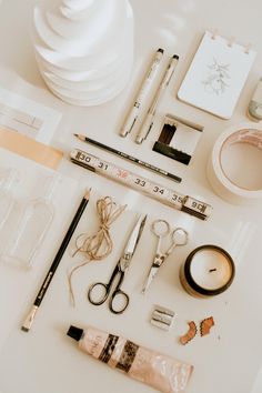 various crafting supplies laid out on top of a white table next to each other