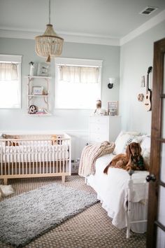 a dog sitting on top of a bed next to a crib in a bedroom