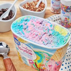 an ice cream container filled with rainbow sprinkles next to bowls of cereal