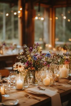 wooden table decorated with candles in mason jars and wildflowers Fairy Garden Themed Wedding, Fairy Lights And Flowers Wedding, Floral Fairy Wedding, Classy Wildflower Wedding, Cozy Summer Wedding, Fairy Garden Theme Wedding, Wildflower And Candle Centerpieces, Garden Fairy Wedding Theme, Garden Wedding Theme Colors