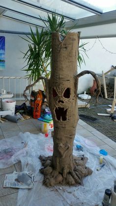 a tree trunk with an evil face carved into it's bark and surrounded by plastic wrap