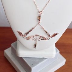 Perfect for the girl who ALWAYS hits her mark - let the Feyre's Bow Necklace, shaped by hand in 14K Rose Gold Fill Wire, bring out your inner huntress.   Inspired by the opening scene in Sarah J. Maas, A Court of Thorns and Roses, where Feyre hunts & brings down the wolf, this officially licensed necklace design features a delicately sculpted bow complete with a chain arrow at it's center. Part of Gilded Girl's ACOTAR Capsule Collection, each of Feyre's Bow Necklace has been created by hand in our studio in Texas from light weight glass beading & wire by our designer, and fellow ACOTAR fan, Danyelle Donaldson. Nine other styles (Rhysand, Cassian, Azriel, Velaris, Ash Arrow, The Masks, Tamlin's Claws, Starfall & Cauldron Blessed) in addition to the Feyre's Bow have been released as of Janua Opening Scene, Grit And Grace, Court Of Thorns And Roses, Center Part, Bow Necklace, Necklace Design, Sarah J Maas, Beading Wire, Sarah J