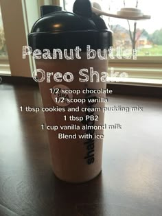 the ingredients for a peanut butter oreo shake are displayed on a wooden table in front of a window