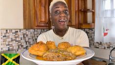 a man holding a plate with croissants on it in front of him