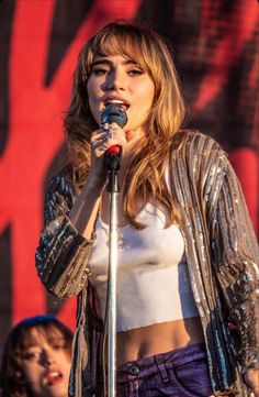 a woman standing on top of a stage holding a microphone