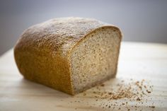 a loaf of bread sitting on top of a wooden cutting board covered in brown sugar