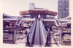 an escalator in front of a building with people on it